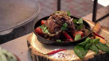Cook prepares a dish of veal meat with tomatoes and greens video