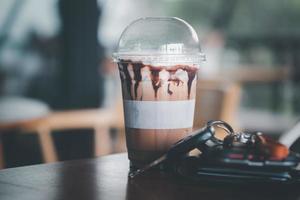 Iced coffee Mocha in plastic glass with men wallet and car key. photo