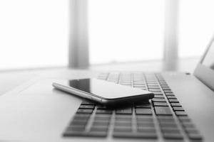 Office workplace with laptop and smartphone on wood table photo