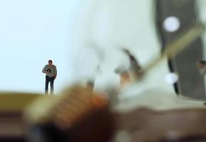 Creative idea concept - miniature photographer with vintage light bulb on open paper notebook photo