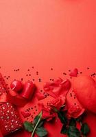 Valentines Day gifts, roses and candles on red backdrop, copy space photo