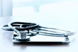 Studio macro of a stethoscope and digital tablet with shallow DOF evenly matched abstract on wood table background copy space photo