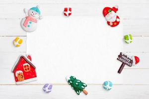 Blank paper od white wooden desk for greeting text, surrounded by Christmas decorations photo