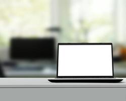 Laptop with blank screen on white desk with blurred background as concept photo