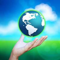 3d earth globe in her hand against blue and green nature background photo