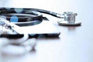 Studio macro of a stethoscope and digital tablet with shallow DOF evenly matched abstract on wood table background copy space photo