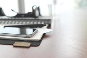 Office workplace with laptop and smart phone and stylus on wood table photo