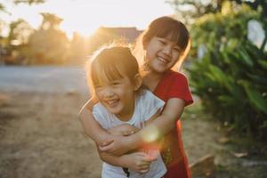 retrato de personas de una expresión facial emocional de sonreír y reír de niños hermanos asiáticos de 6 años. familia sana y felicidad niños jugando juntos concepto foto