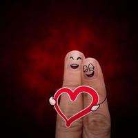 happy finger couple in love with painted smiley and hold heart photo