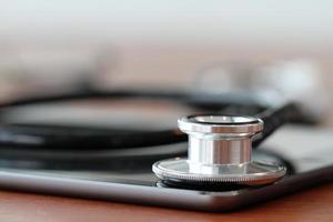 Studio macro of a stethoscope and digital tablet with shallow DOF evenly matched abstract on wood table background copy space photo