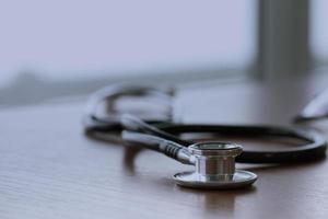 Studio macro of a stethoscope and digital tablet with shallow DOF evenly matched abstract on wood table background copy space photo