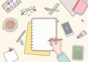 A desk untidy with office supplies. A hand is writing something on a notebook. vector