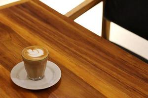 A cup of latte coffee on the cafe table photo