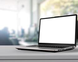 Laptop with blank screen on white desk with blurred background as concept photo