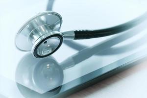 Studio macro of a stethoscope and digital tablet with shallow DOF evenly matched abstract on wood table background copy space photo