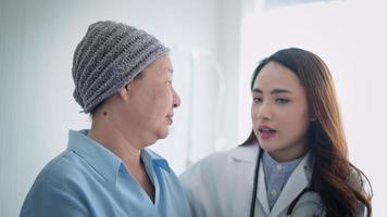 patiente atteinte de cancer portant un foulard après une consultation de chimiothérapie et un médecin de visite à l'hôpital. video