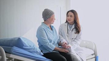 kankerpatiënt vrouw die hoofddoek draagt na raadpleging van chemotherapie en bezoekende arts in het ziekenhuis. video