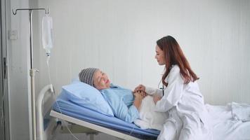 Cancer patient woman wearing head scarf after chemotherapy consulting and visiting doctor in hospital. video