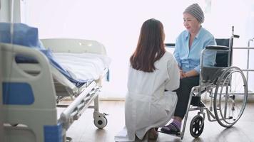 Cancer patient woman wearing head scarf after chemotherapy consulting and visiting doctor in hospital. video