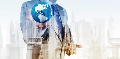 Double exposure of business engineer holding the earth and abstract city as concept photo