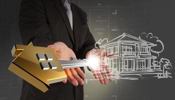 businessman showing key of  building as development concept photo