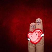 una pareja feliz enamorada de una carita pintada y un corazón foto