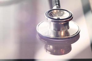 Studio macro of a stethoscope and digital tablet with shallow DOF evenly matched abstract on wood table background copy space photo