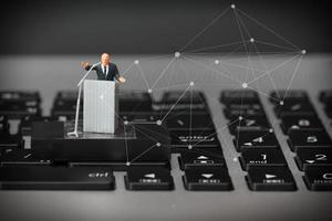 concepto de conferencia en línea: orador en miniatura en una conferencia de negocios en una computadora portátil con diagrama de red social foto