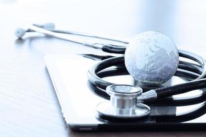 Studio macro of a stethoscope and texture globe with digital tablet with shallow DOF evenly matched abstract as medical network concept photo