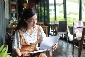 Asian women reading book and smiling and happy Relaxing in a coffee shop photo
