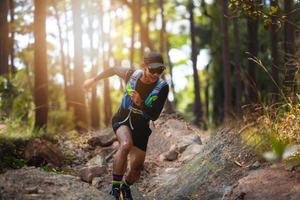 A man Runner of Trail . and athlete's feet wearing sports shoes for trail running in the forest photo