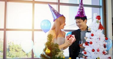 Asian couple lover are giving a gift box with Christmas gift in Christmas holiday and happy new year patty photo