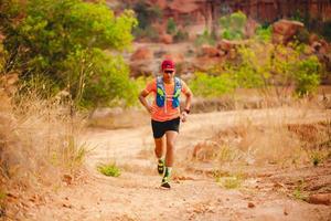 A man Runner of Trail . and athlete's feet wearing sports shoes for trail running in the mountains photo