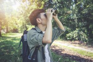 Asian Group of young people Hiking with friends backpacks walking together and using binoculars ,Relax time on holiday concept travel photo