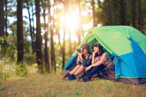 un grupo de amigos asiáticos turistas toman fotos juntos con felicidad en verano mientras acampan