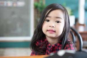 linda niña asiática sentada sonriendo foto