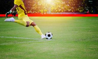 fútbol o jugador de fútbol de pie con la pelota en el campo para patear la pelota de fútbol en el estadio de fútbol