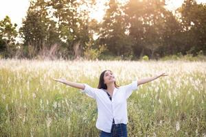 Asian women happy smile on relaxing time at the meadow and grass photo