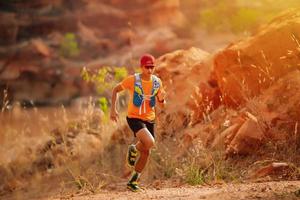 A man Runner of Trail and athlete's feet wearing sports shoes for trail running in the forest photo