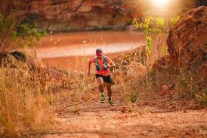 A man Runner of Trail . and athlete's feet wearing sports shoes for trail running in the mountains photo