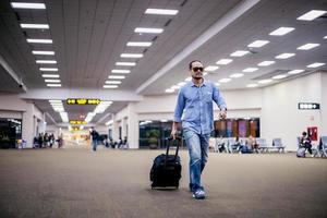 Asian man traveler with suitcases walking and transportation at an airport