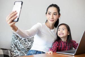 Mom and daughters are taking selfies and laughing and smiling happy photo