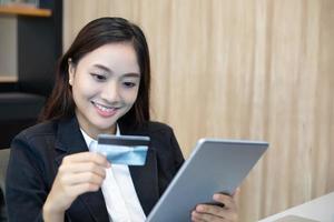 business woman asian using tablet and credit card shopping online photo