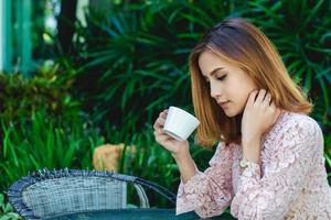Mujer de negocios asiática está trabajando y tomando café en el momento de relajarse