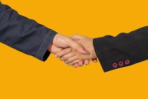close up of business handshake isolate on yellow blackground photo