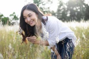 Asian women happy smile on relaxing time at the meadow and grass photo