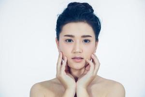 las mujeres asiáticas hermosas con la piel limpia y fresca se tocan su propia cara. tratamiento facial . cosmetología, belleza y spa foto