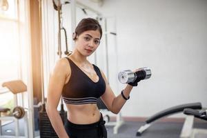 beautiful muscular fit woman exercising building muscles and fitness woman doing exercises in the gym. Fitness - concept of healthy lifestyle photo