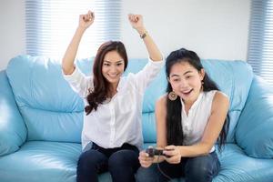 dos mujeres competitivas amigas jugando videojuegos y emocionado feliz alegre en casa foto