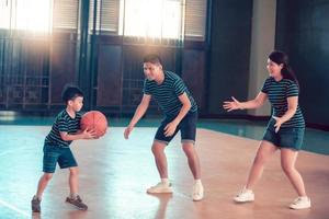 familia asiática jugando baloncesto juntos. familia feliz pasando tiempo libre juntos en vacaciones foto